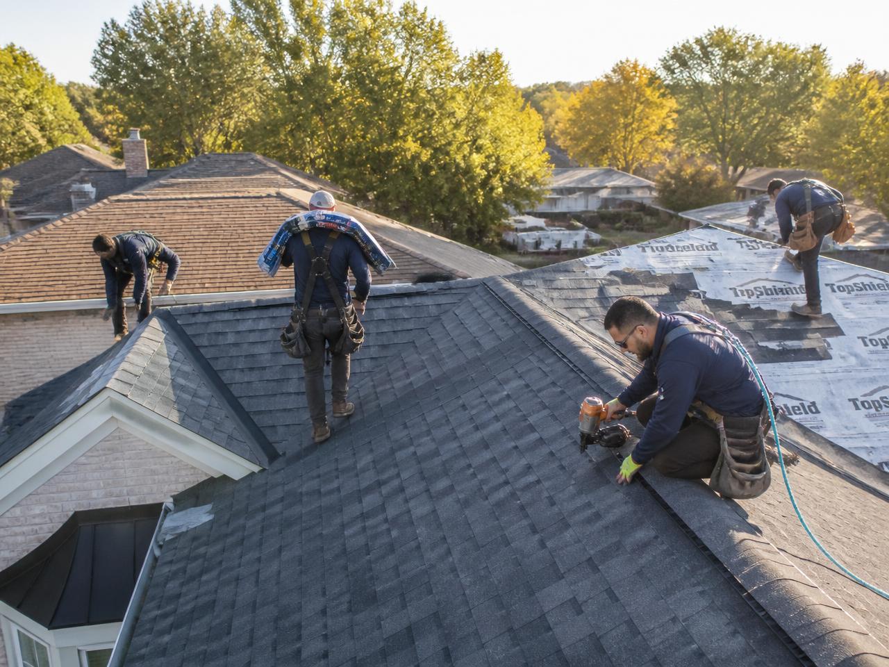 Professional roofing crew installing shingles on a residential roof